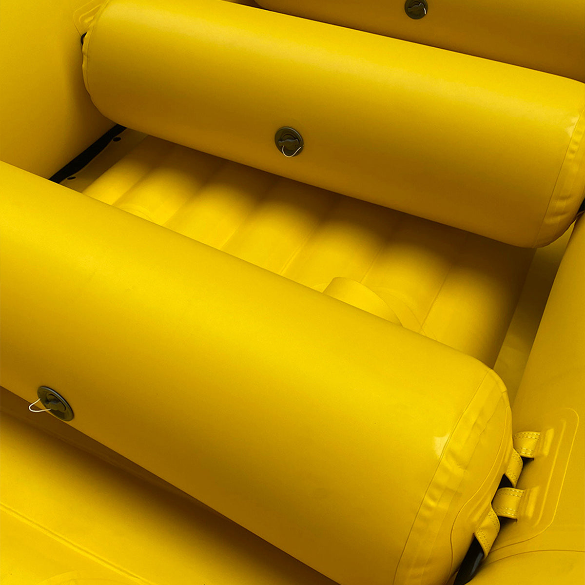 Yellow inflatable raft with multiple padded tubes and circular valve details