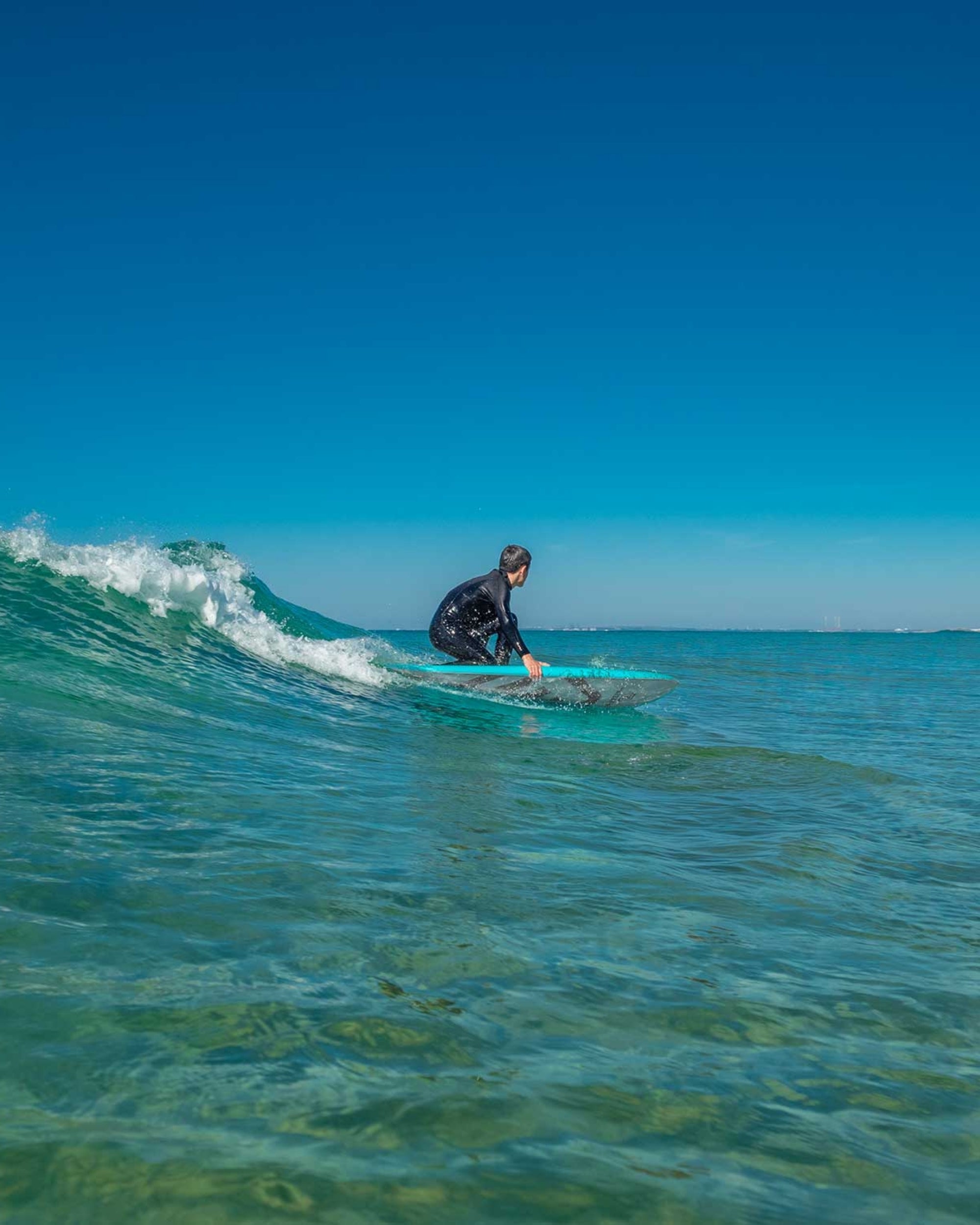 Blue surfboard being ridden by a surfer in ocean waves