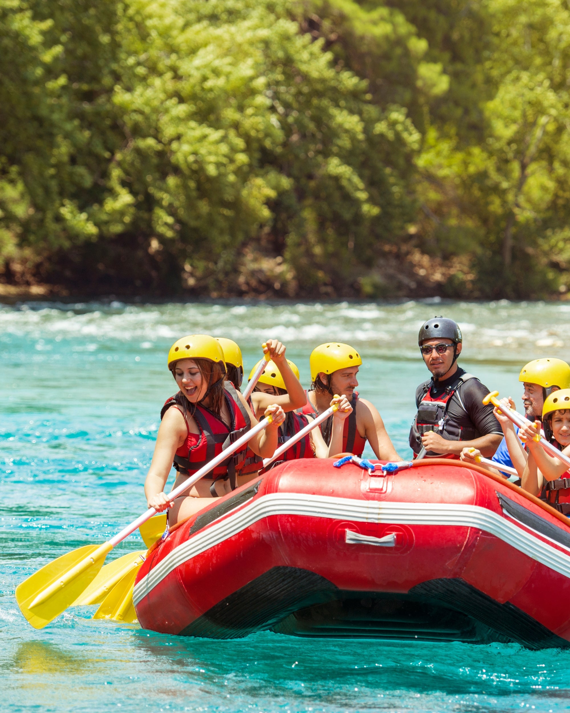 Red inflatable raft on water with passengers wearing life jackets