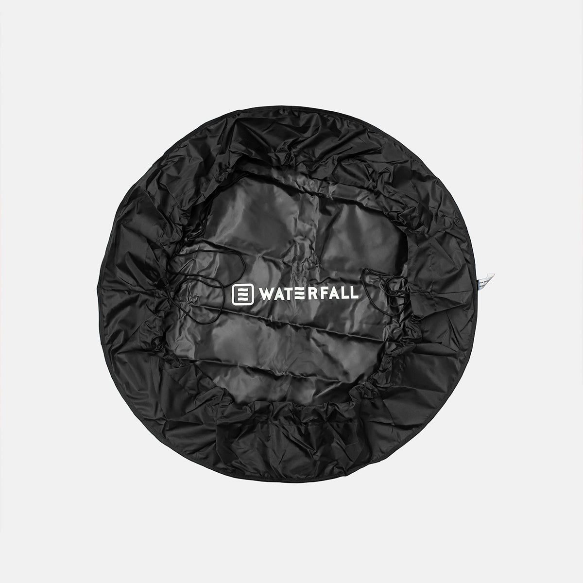 Black circular wetsuit bag with WATERFALL logo on crinkled fabric surface