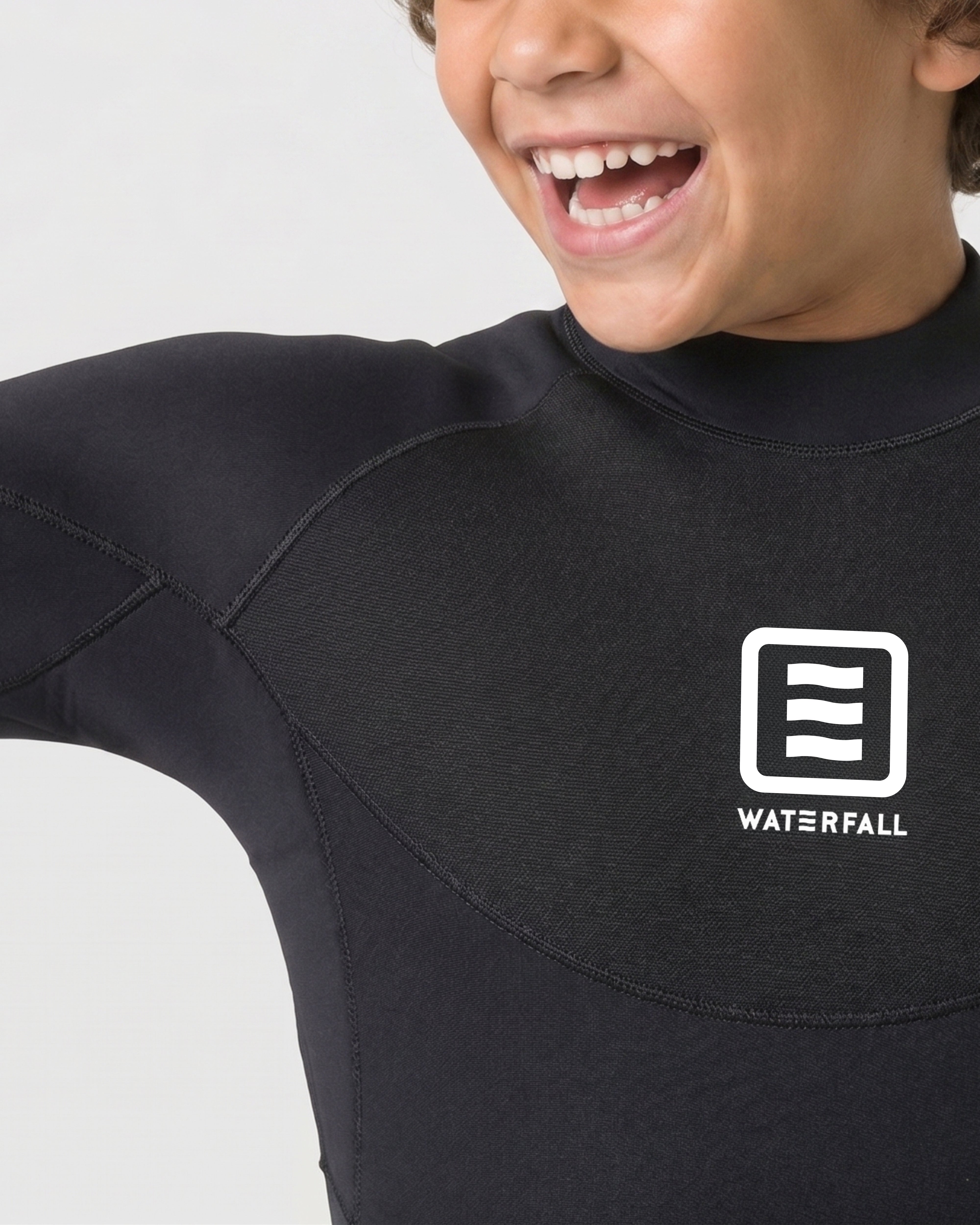 Kids dark black wetsuit close-up of chest logo and stitched seam panels