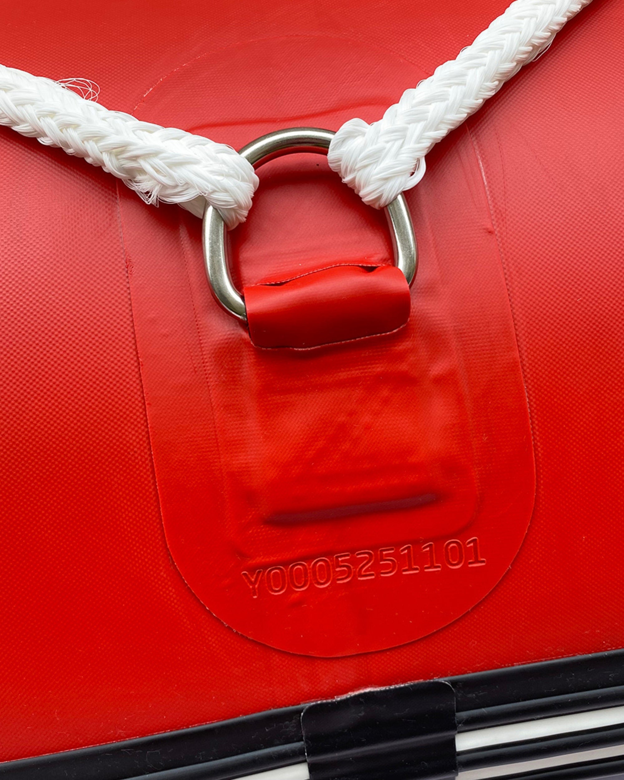 Red inflatable raft carry handle with white rope and metal D-ring