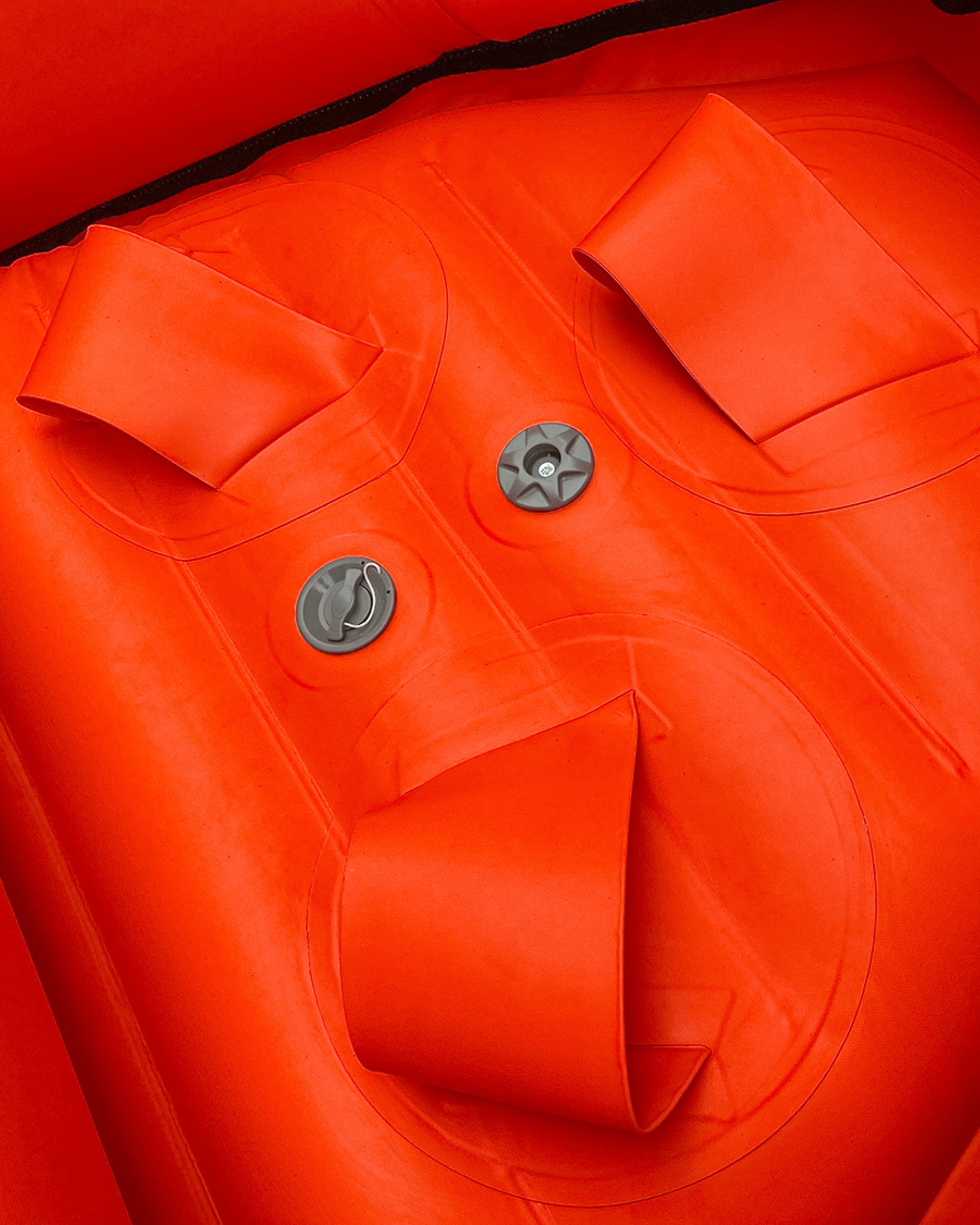 Red inflatable raft deck with round drain cap and molded compartments