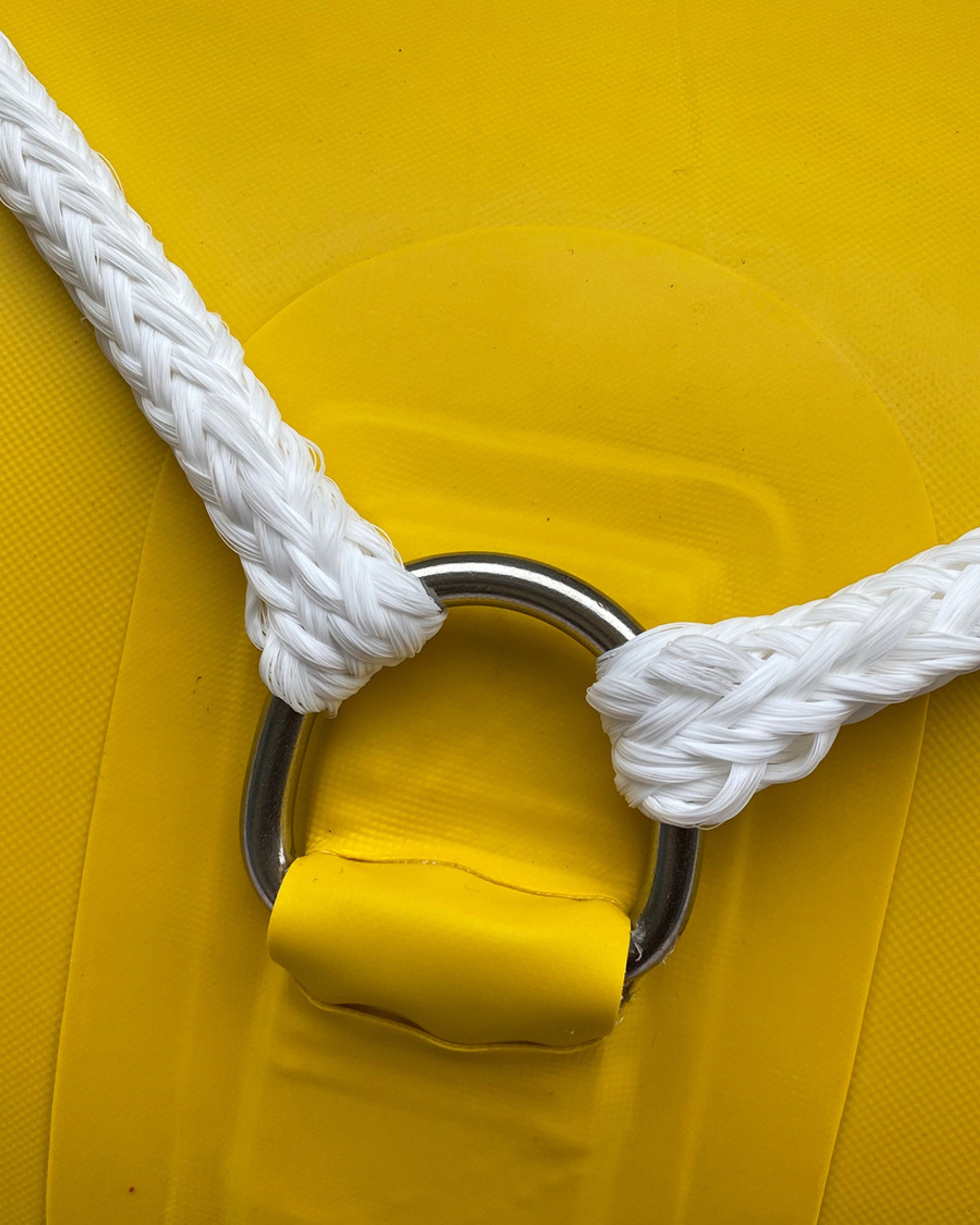 Close-up of yellow inflatable raft seat and white braided carry rope
