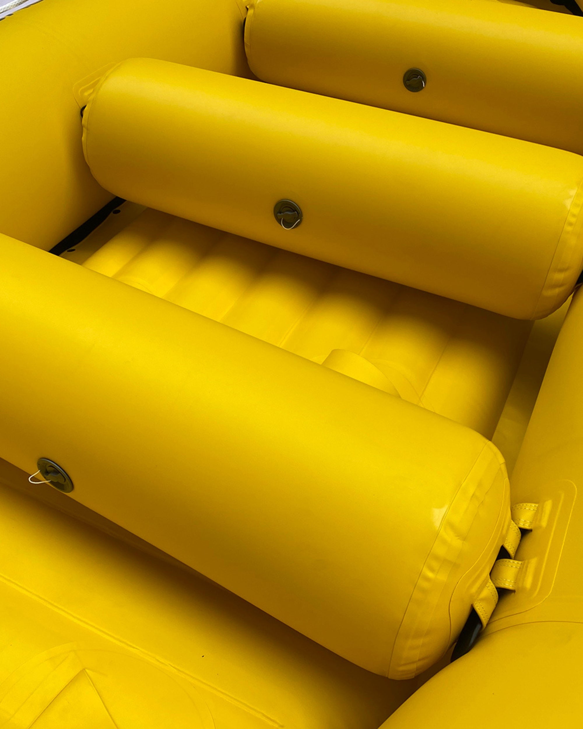 Close-up of yellow inflatable raft with padded seat tubes and round fasteners