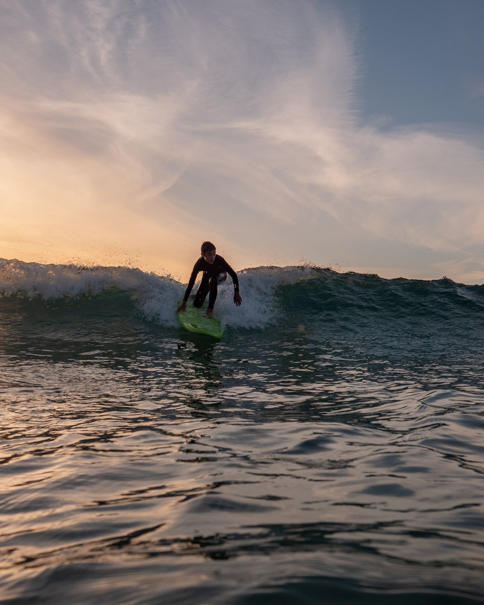Neon green surfboard ridden by surfer on ocean waves