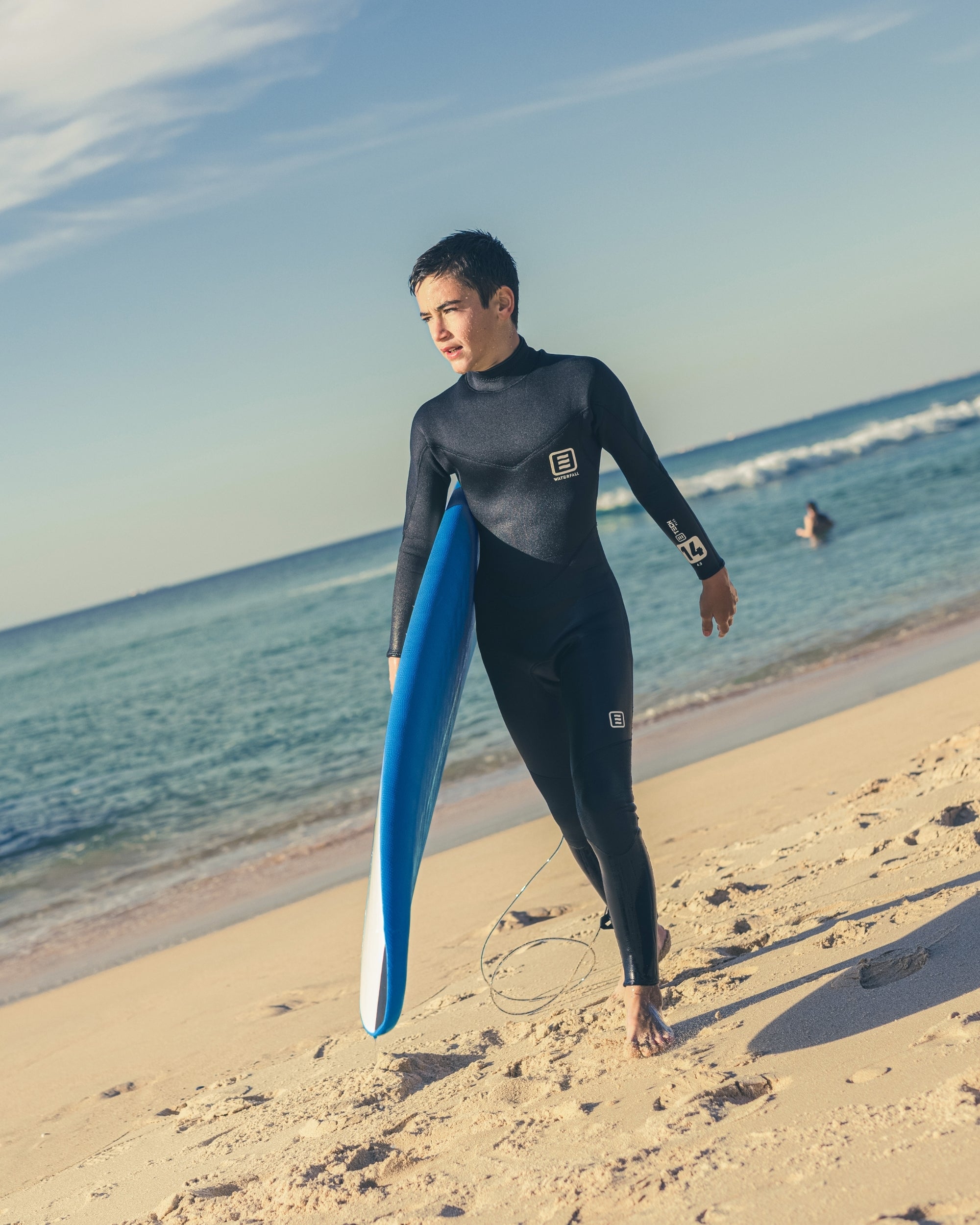 Blue 7" surfboard core with black traction dots, held upright